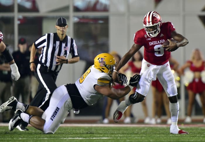 Indiana quarterback Michael Penix Jr. (9) evades a tackle against Idaho defensive lineman Noah Elliss (99). Mandatory Credit: Marc Lebryk-USA TODAY Sports
